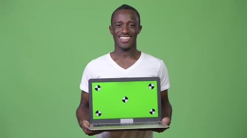 Young Adult Holds Up Laptop with Chroma Key Screen