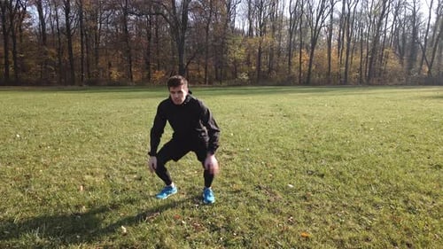 Man Stretching Legs Before Exercise in Autumn Park