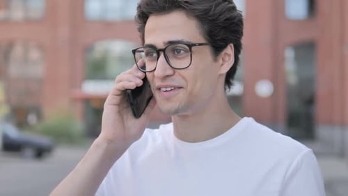 Young Man Talking on Phone Outside