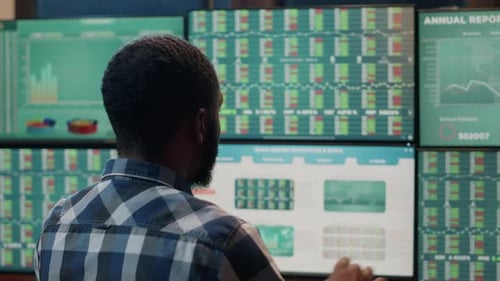 Man Analyzing Stock Data on Multiple Monitors