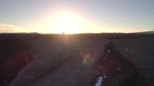 Person hiking on ridge of sand dune against the sun