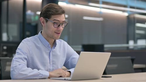 Young Man on Video Call Working on Laptop