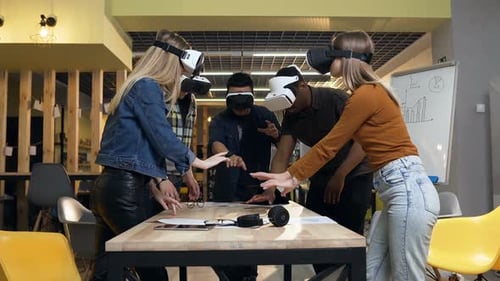 Group of Young People Having Fun with VR Virtual Reality Glasses in the Modern Office