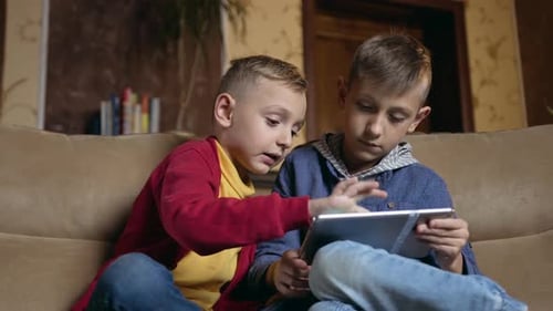 Two Boys Playing on Tablet at Home