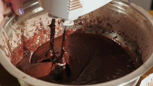 Electric Mixer Blending Chocolate Cake Batter in Bowl