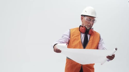 Adult Engineer Man in Uniform Studies the Working Drawings