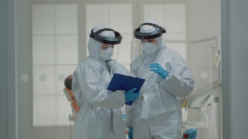 Medical Staff Discussing File Wearing Protective Gear