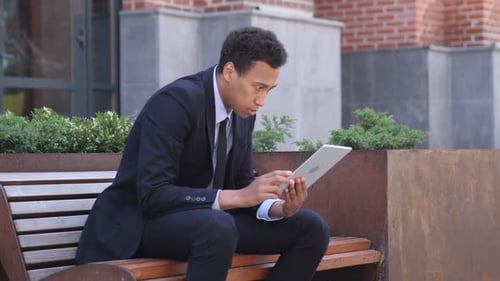 Shocked Businessman Using Tablet Device Outdoors