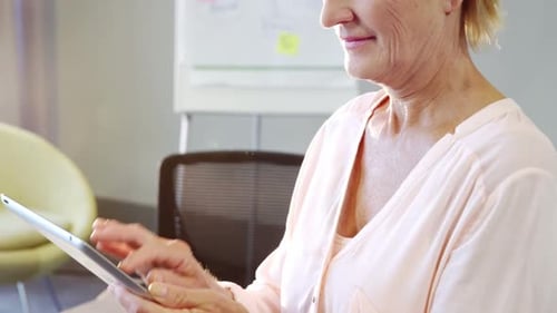 Smiling Woman Using Tablet in Bright Office