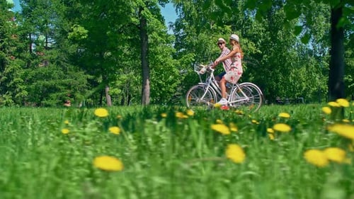 Couple Enjoying Bike Ride Through Sunny Park
