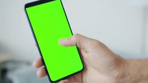 Closeup Slow Motion of Male Hand Swiping Green Smartphone Screen Indoors