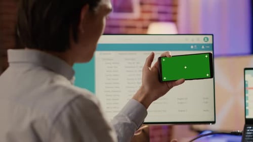 Office Worker Looking at Horizontal Greenscreen on Smartphone