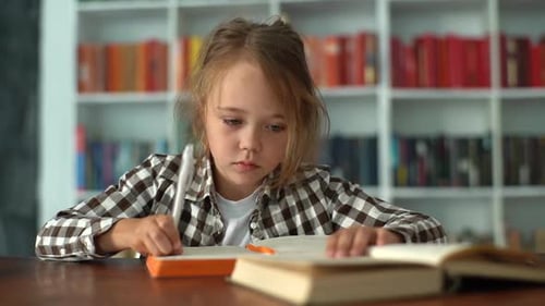 Close Up Portrait of Caucasian Elementary Child School Girl Using Pencil Writing to Note Book Doing