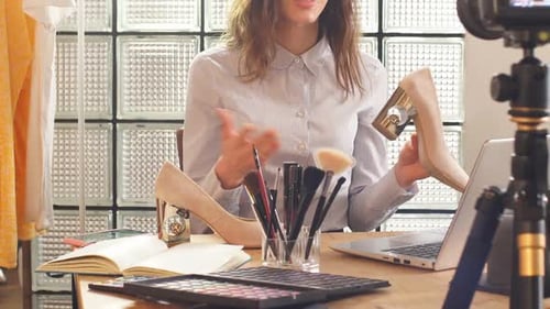 Transmisión en línea de una bloguera de belleza en casa: una mujer comparte nuevos modelos de zapatos con sus suscriptores