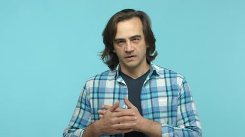 Close Up of Middleaged Man with Bristle Feeling Heartfelt and Passionate Holding Hands on Chest