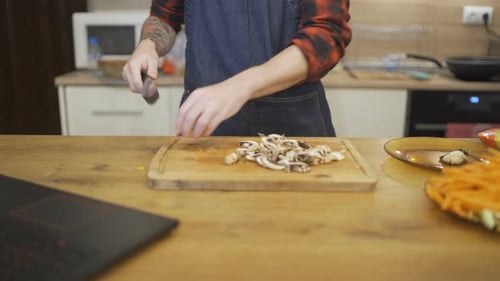 Young Man Husband Chopping Mushrooms Preparing Thanksgiving or Christmas Meal