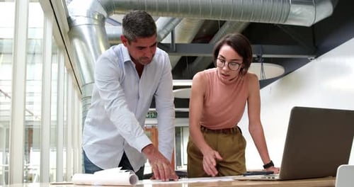 Business people discussing over blueprint in modern office 4k