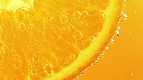 Luftblasen um eine Orangenscheibe.