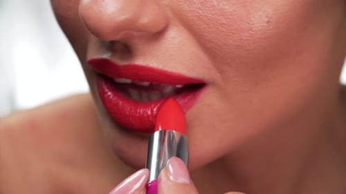 Woman Applies Red Lipstick in Close Up