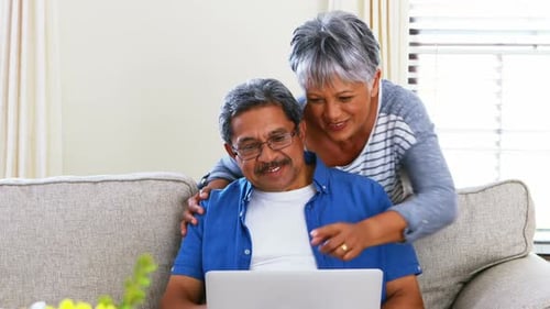 Senior Couple Video Calling on Laptop at Home