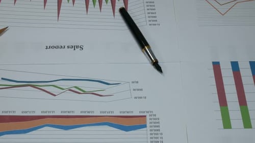 Financial Charts with Pen on Sales Report