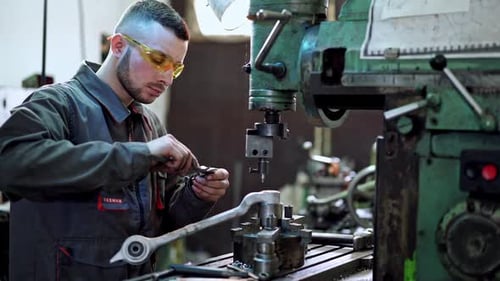 Arbeiter in der Fabrik an der Maschine. Arbeiter in Schutzkleidung in Fabrik mit Maschine