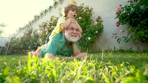 Grandfather and Child Playing in the Summer Garden