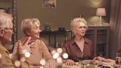Seniors Playing Guessing Game at Dinner Party