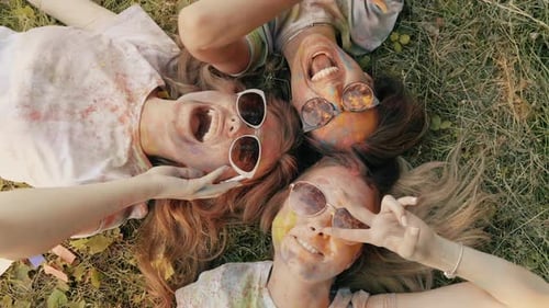 Three happy beautiful female making party at Holi colors festival in summer time