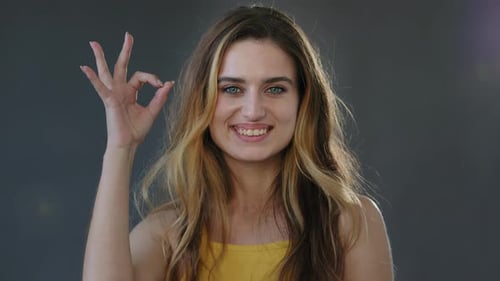 Smiling Woman Gives Okay Hand Gesture Close Up