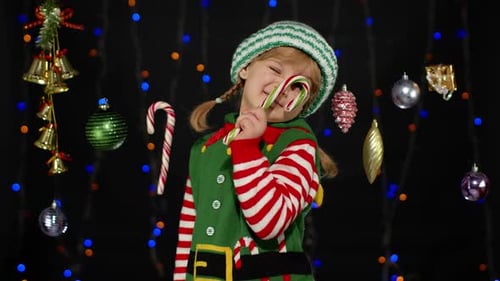 Child in Elf Costume With Candy Cane