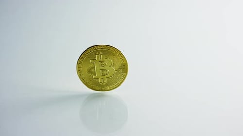 Goldene Bitcoin und Dollar auf weißem Hintergrund