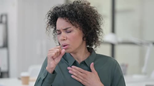 Young Adult Woman Coughing in Office Setting