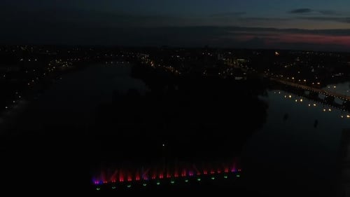 Hermosa fuente danzante. Foto aérea de la colorida fuente musical iluminada al anochecer