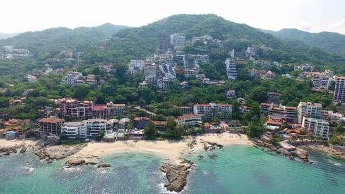 Aerial View of Tropical Beachfront with Lush Mountainside