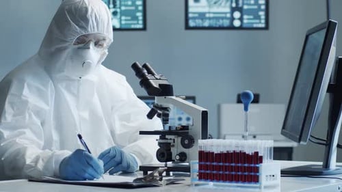 Scientist Working in Laboratory with Microscope and Samples
