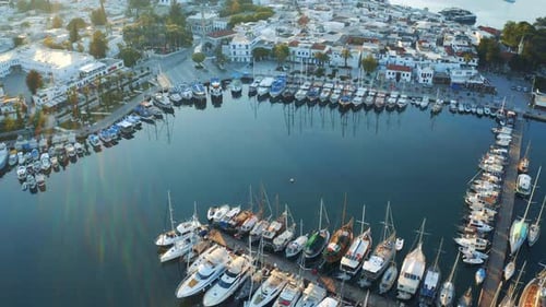 Langsam aufsteigender Schuss über Yachten im Meer zeigt die Bucht von Bodrum gegen den Sonnenuntergang