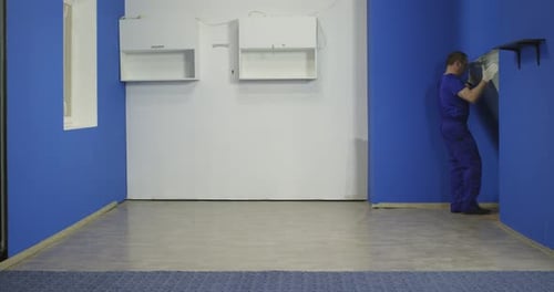 Men moving a refrigerator into the room