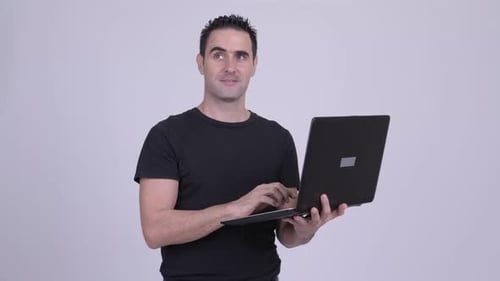 Man Using Laptop Computer and Smiling