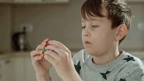 Boy Solving Rubik's Cube in Home Interior