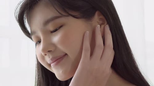 Young Woman Gently Touches Her Face in Studio