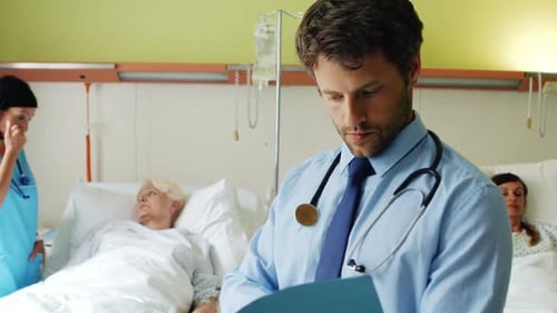 Doctor Reviews Patient Charts in Hospital Ward