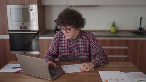 Young Adult Working at Home on Laptop