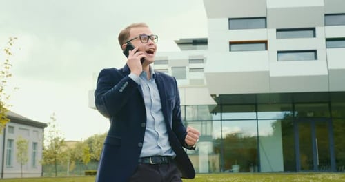 Excited Businessman Celebrates Good News on Cellphone