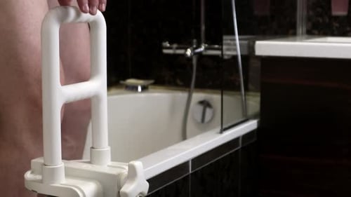 Man Using Bathtub Safety Rail in Bathroom