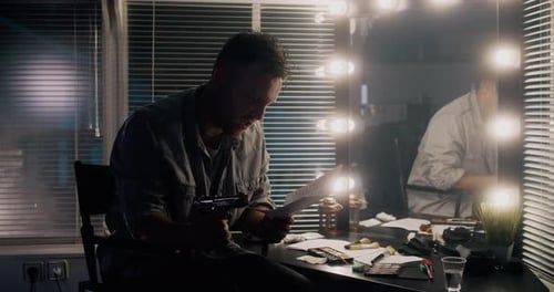 Actor With Gun Rehearsing Lines in Dressing Room