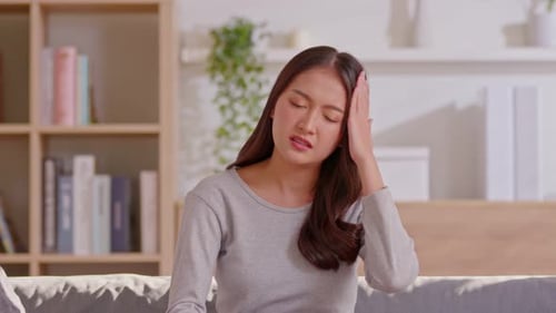 Woman with Headache Rubbing Head at Home