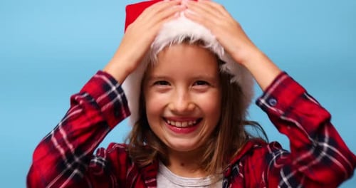 Smiling Child Wearing a Santa Hat