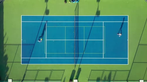 Top-down View on a Tennis Court Where Energetic Athletes Are Playing Tennis