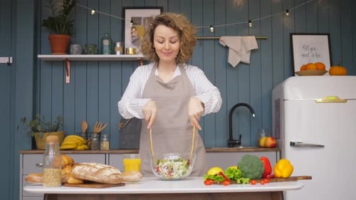 Woman Enjoys Making Salad in Sunny Kitchen